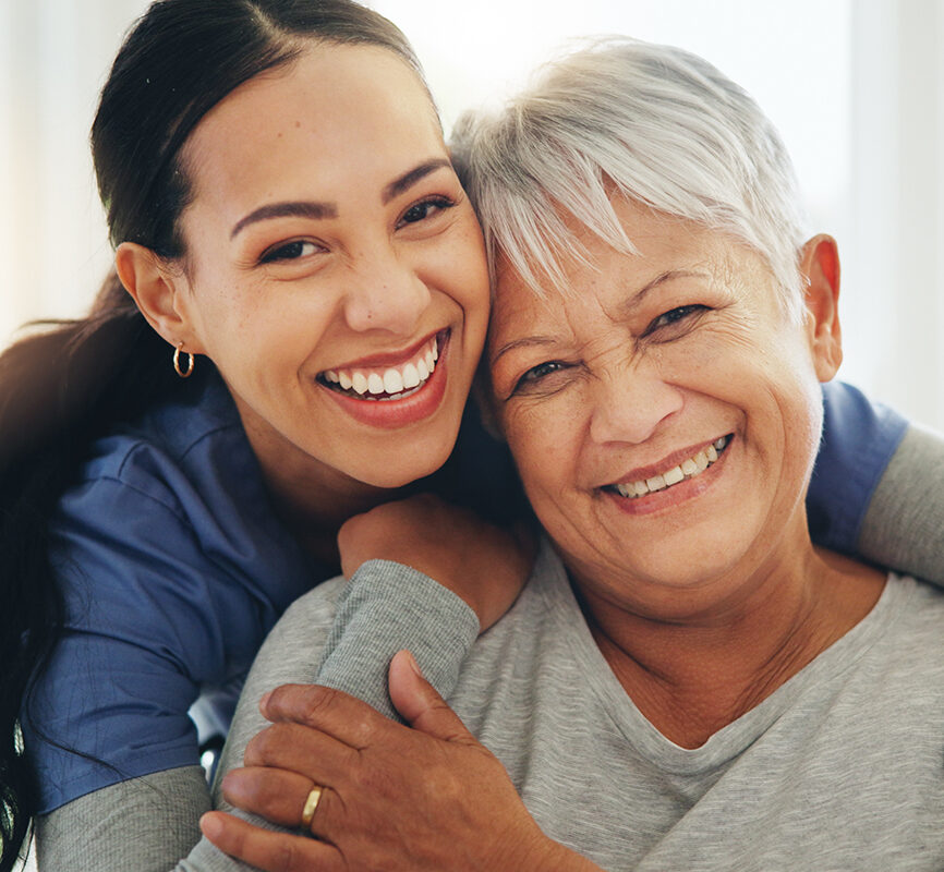 Happy woman, nurse and hug senior patient in elderly care, support or trust at old age home. Portrait of mature female person, doctor or medical caregiver hugging with smile for embrace at house